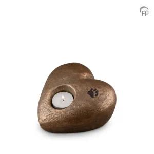 Herzförmiger bronzefarbener Kerzenhalter mit einem kleinen Pfotenabdruck auf der oberen rechten Seite, der eine weiße Teelichtkerze hält. Aurora Tierkrematorium